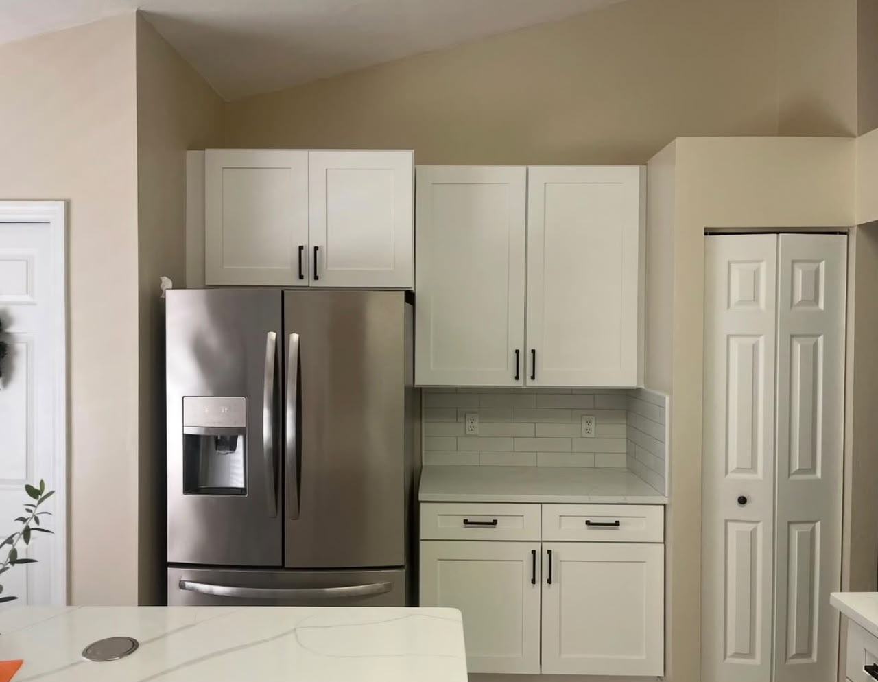 White kitchen cabinets and stainless refrigerator